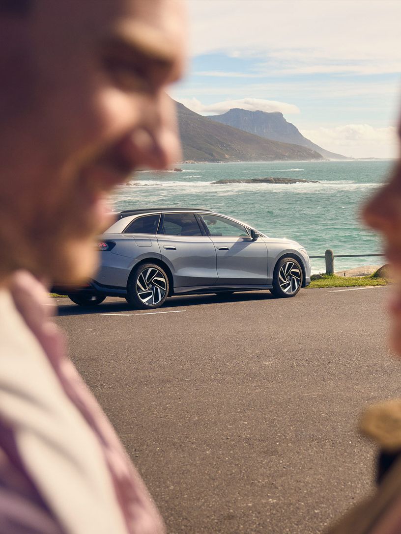 Zwei Personen umarmen sich vor einem ID.7 Tourer.