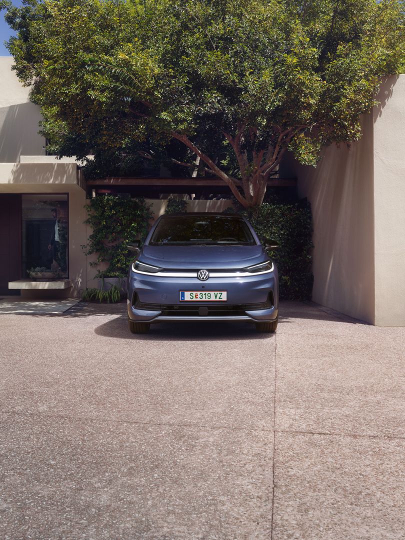 Ein blauer VW ID.3 Neo parkt vor einem Einfamilienhaus
