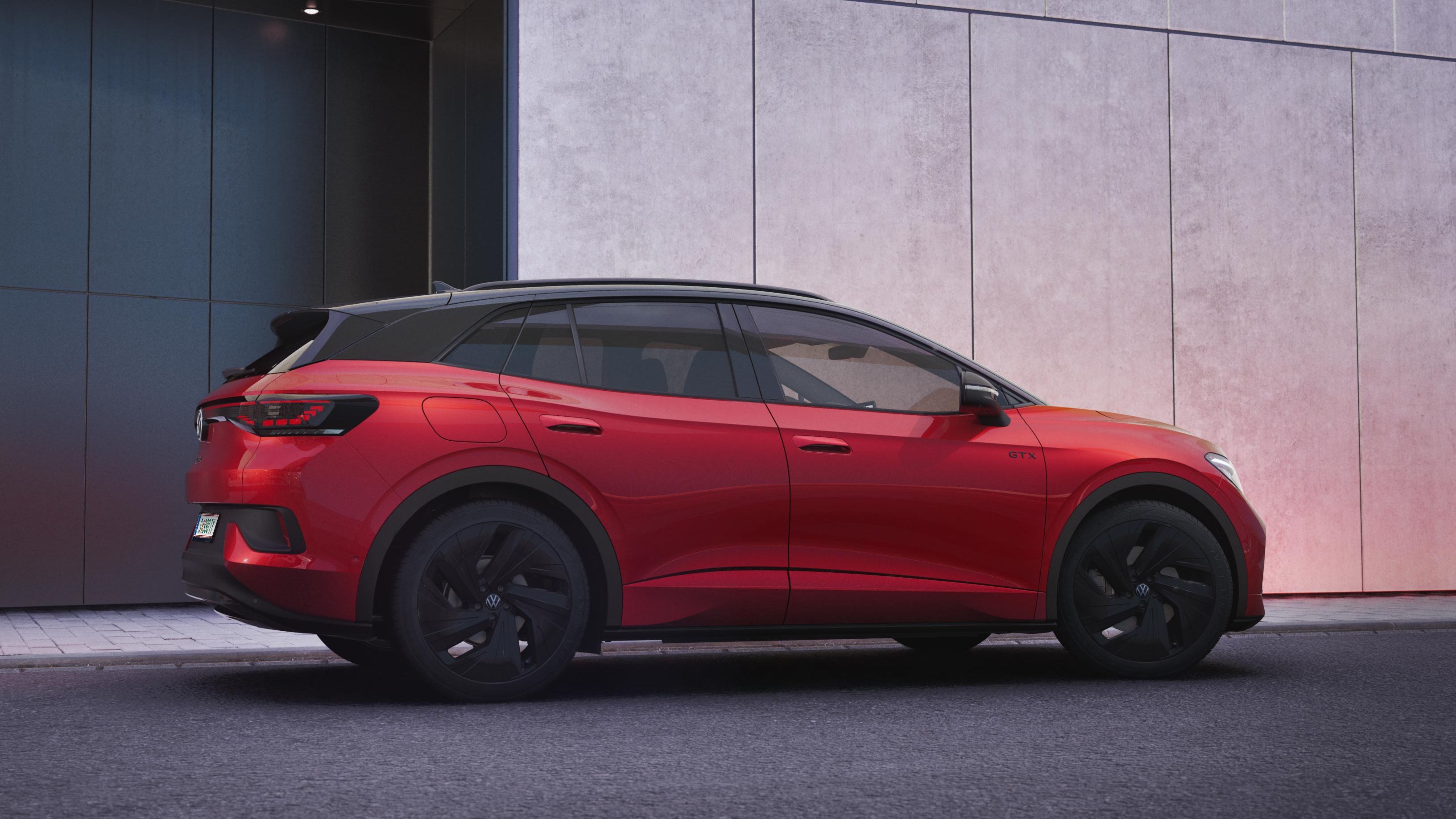 Ein roter VW ID.4 GTX parkt seitlich vor einer modernen Hauswand.