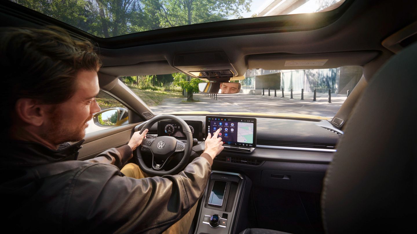 VW T-Roc Ein Mann bedient auf dem Infotainment-Display in seinem Volkswagen T-Roc Android Auto über die App-Connect Schnittstelle.