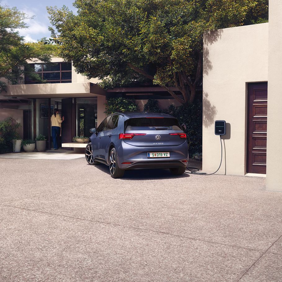 Ein blauer VW ID.3 Neo lädt an einer Wallbox vor einem Einfamilienhaus