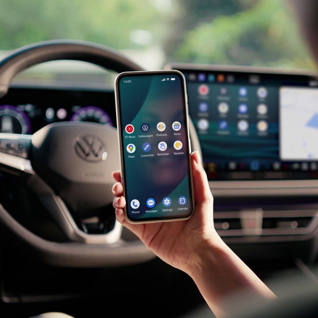 Frau sitzt auf dem Fahrersitz und spiegelt Smartphone per App Connect auf dem Fahrzeugdisplay