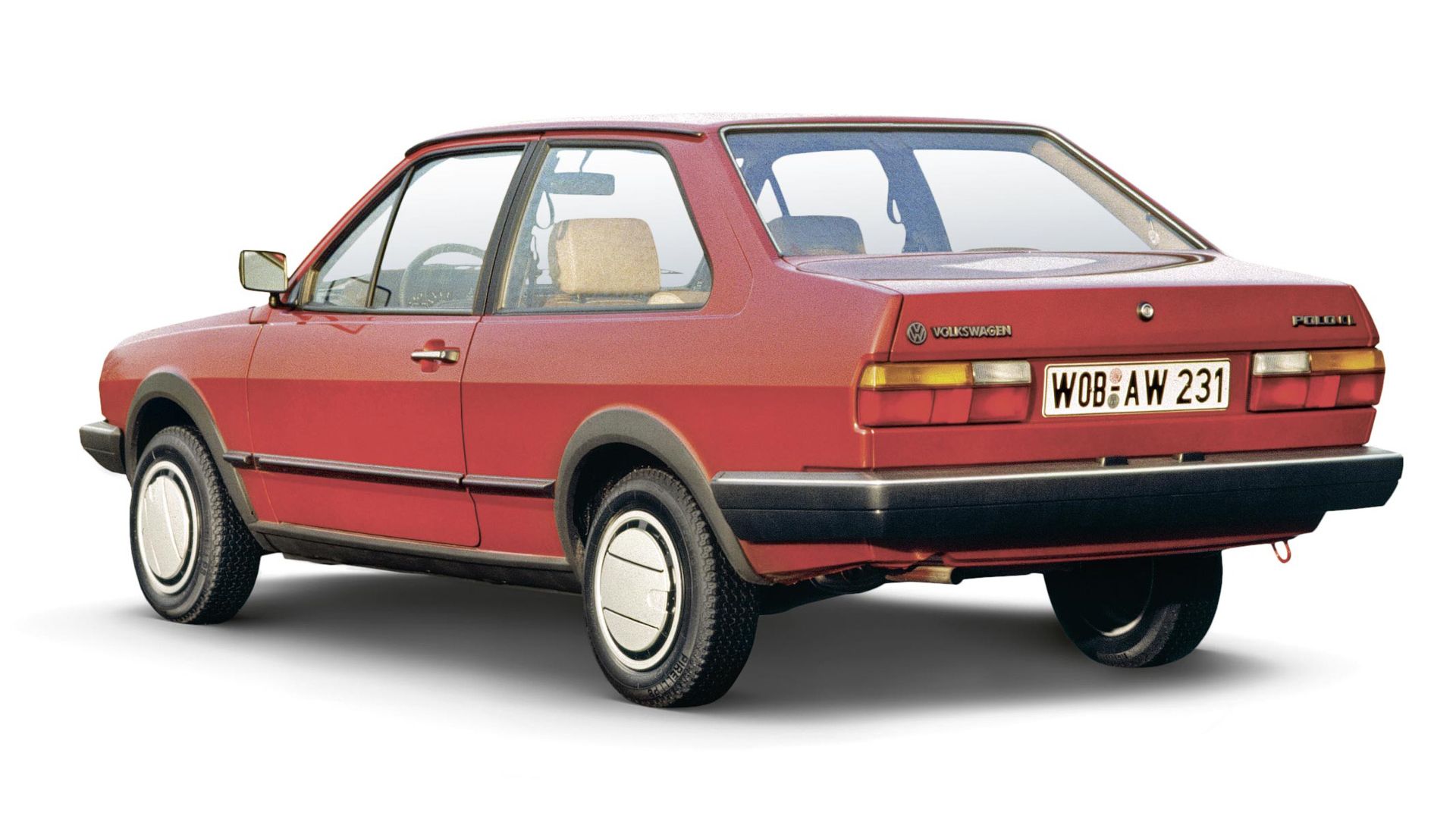 Das Bild zeigt einen roten VW Polo Stufenheck der 80er Jahre. Das Fahrzeug hat ein kantiges Design und ist aus der Seitenansicht zu sehen. Die Nummernschilder sind deutlich sichtbar.