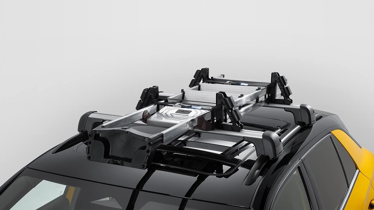 Volkswagen Dachträger mit Universalhaltern und befestigter Leiter auf dem Dach eines gelben Volkswagen T-Roc.