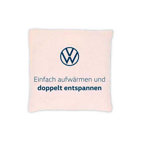 Ein Sitzkissen mit VW-Logo und dem Text "Einfach aufwärmen und doppelt entspannen". Das Kissen ist quadratisch und hat eine beige Farbe.