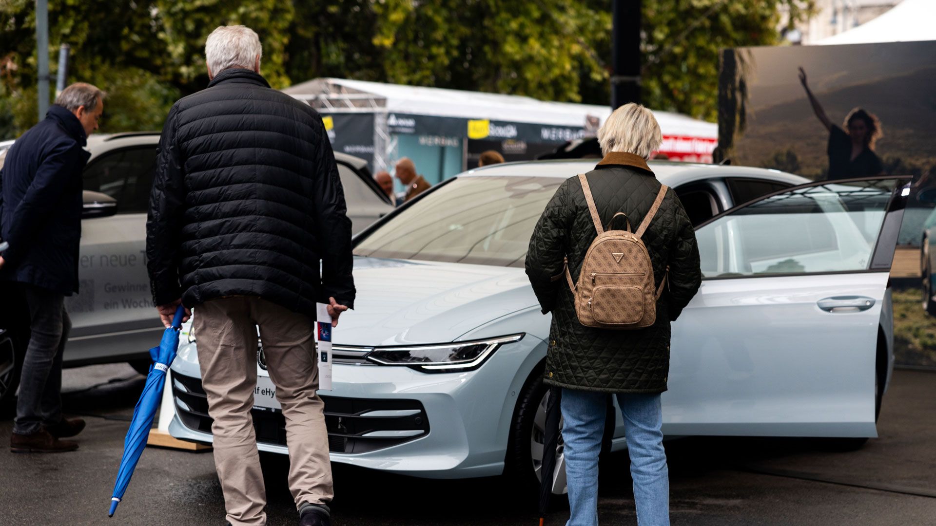 Besucher der Wiener Elektro Tage 2025 besichtigen den VW Golf Rabbit eHybrid.