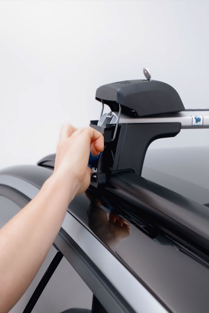 Eine Frau beim befestigen eines Volkswagen Dachträgers.