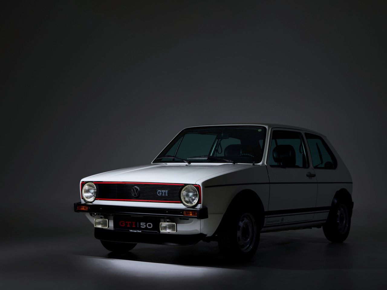 Der Golf GTI 1 mit weißer Lackierung schräg von vorne.