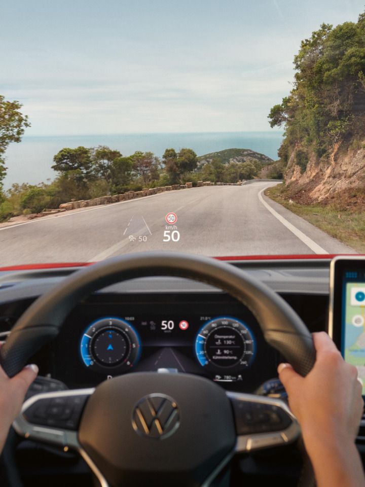 Fahreransicht im VW Tiguan mit Navigationshinweisen des Head-up-Displays auf der Frontscheibe.