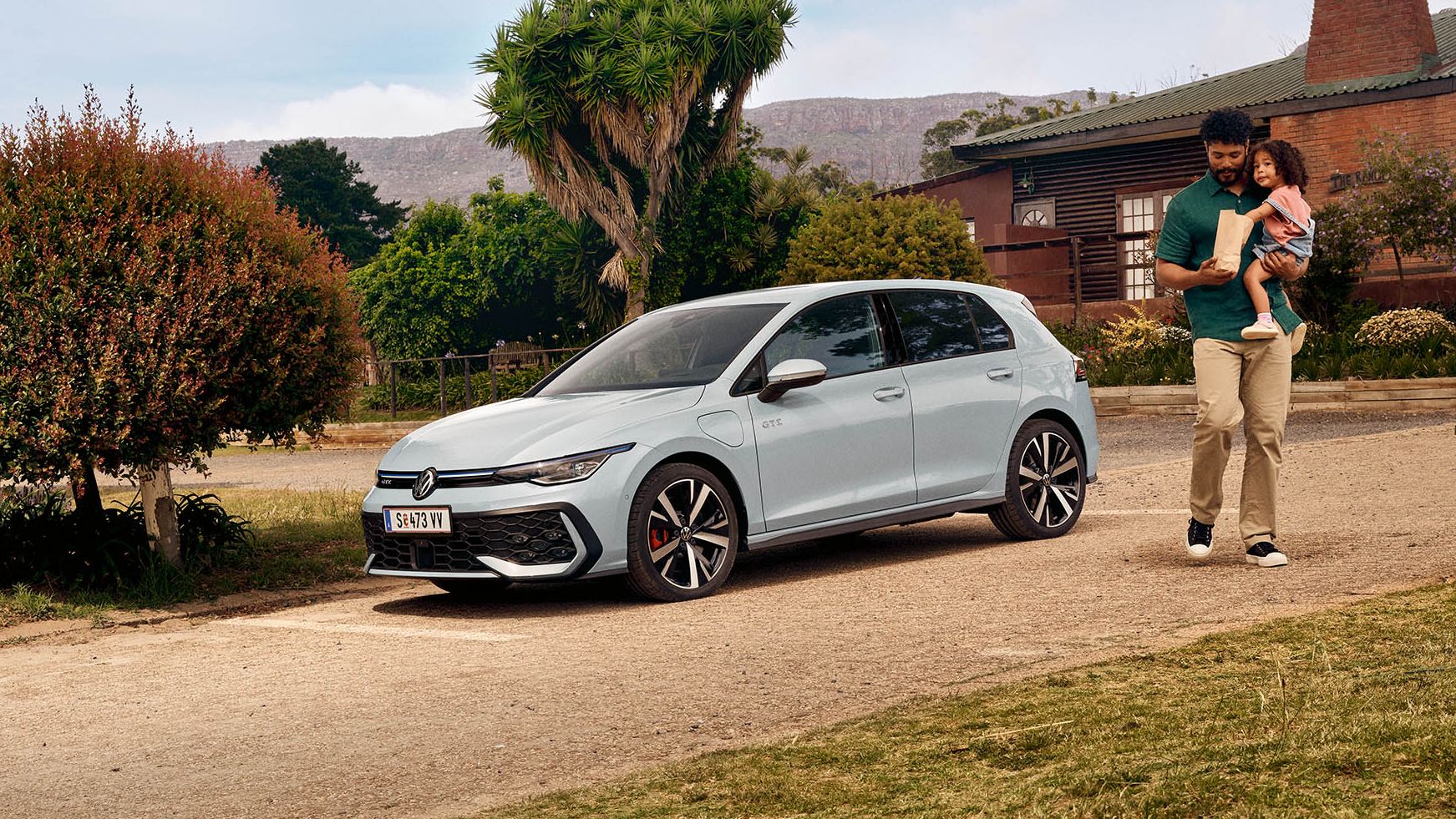Der VW Golf GTE steht auf einem Parkplatz vor einem Haus.