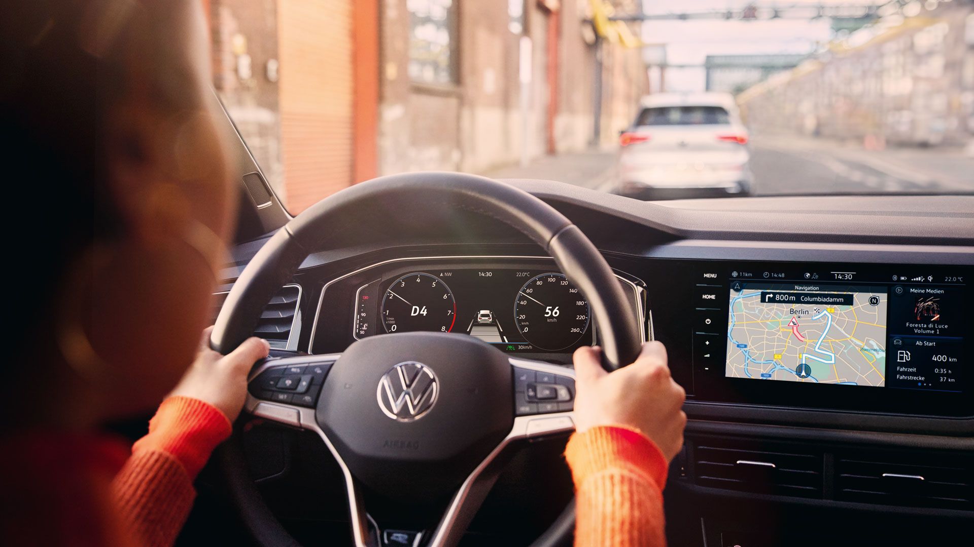 Eine Frau fährt einen VW Polo mit aktiver Navigation auf dem Display des Infotainment-Systems.