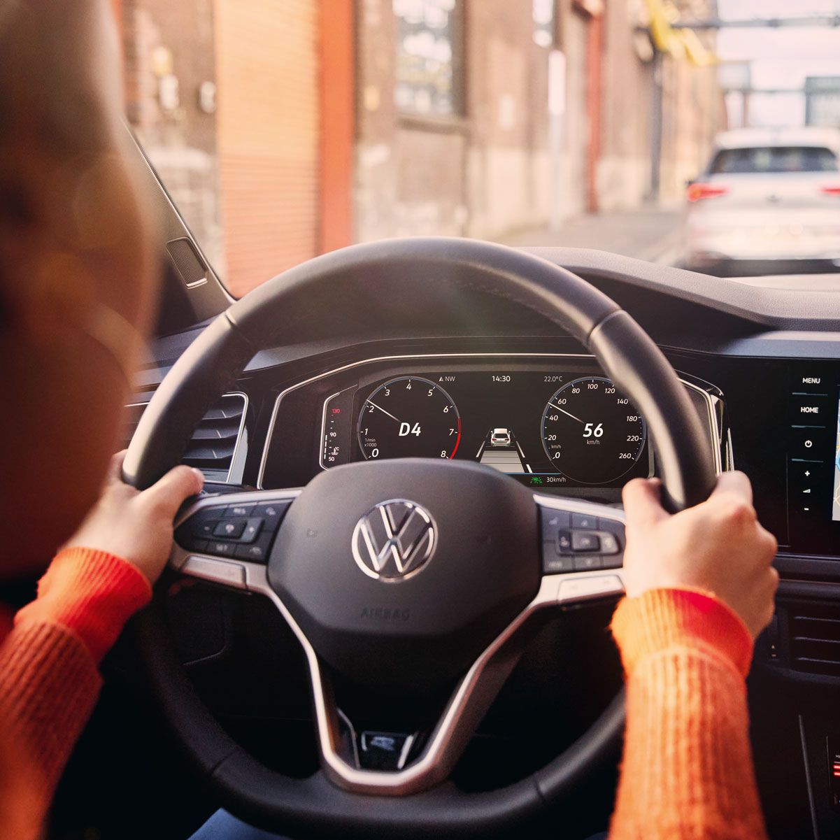 Eine Frau fährt einen VW Polo mit aktiver Navigation auf dem Display des Infotainment-Systems.