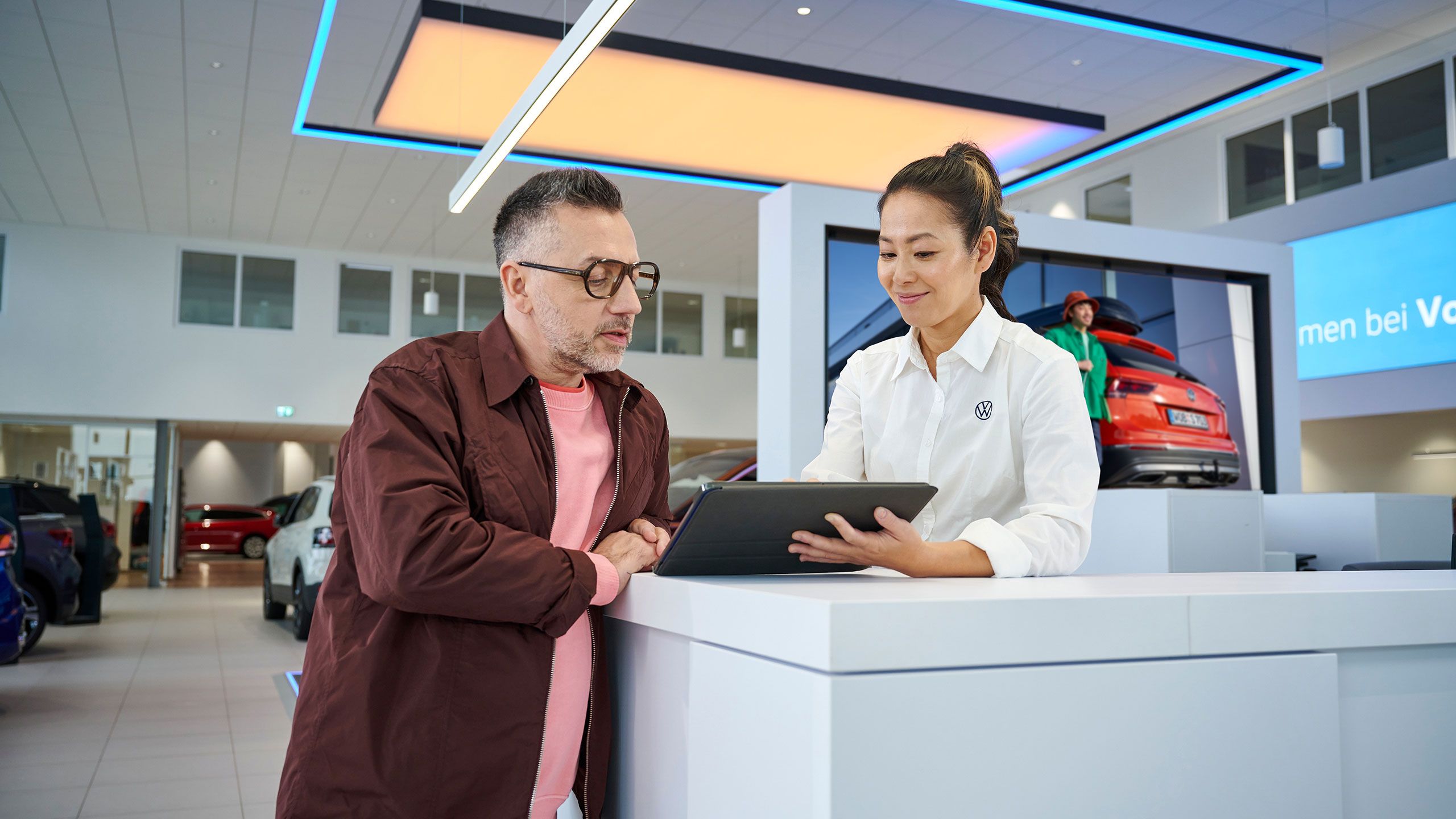 Eine Frau gibt einem Mann mithilfe eines Tablets Informationen.
