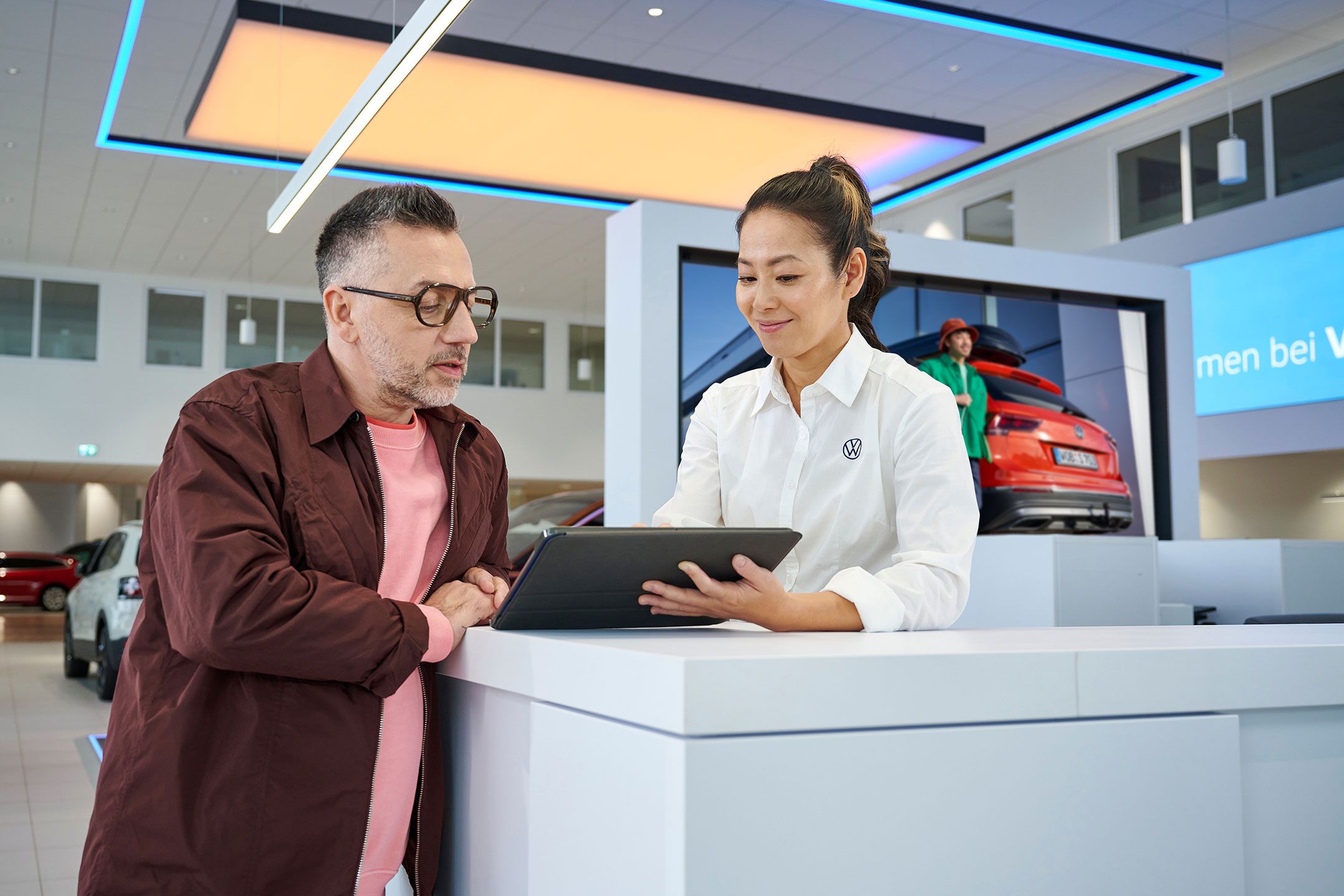 Eine Frau gibt einem Mann mithilfe eines Tablets Informationen.
