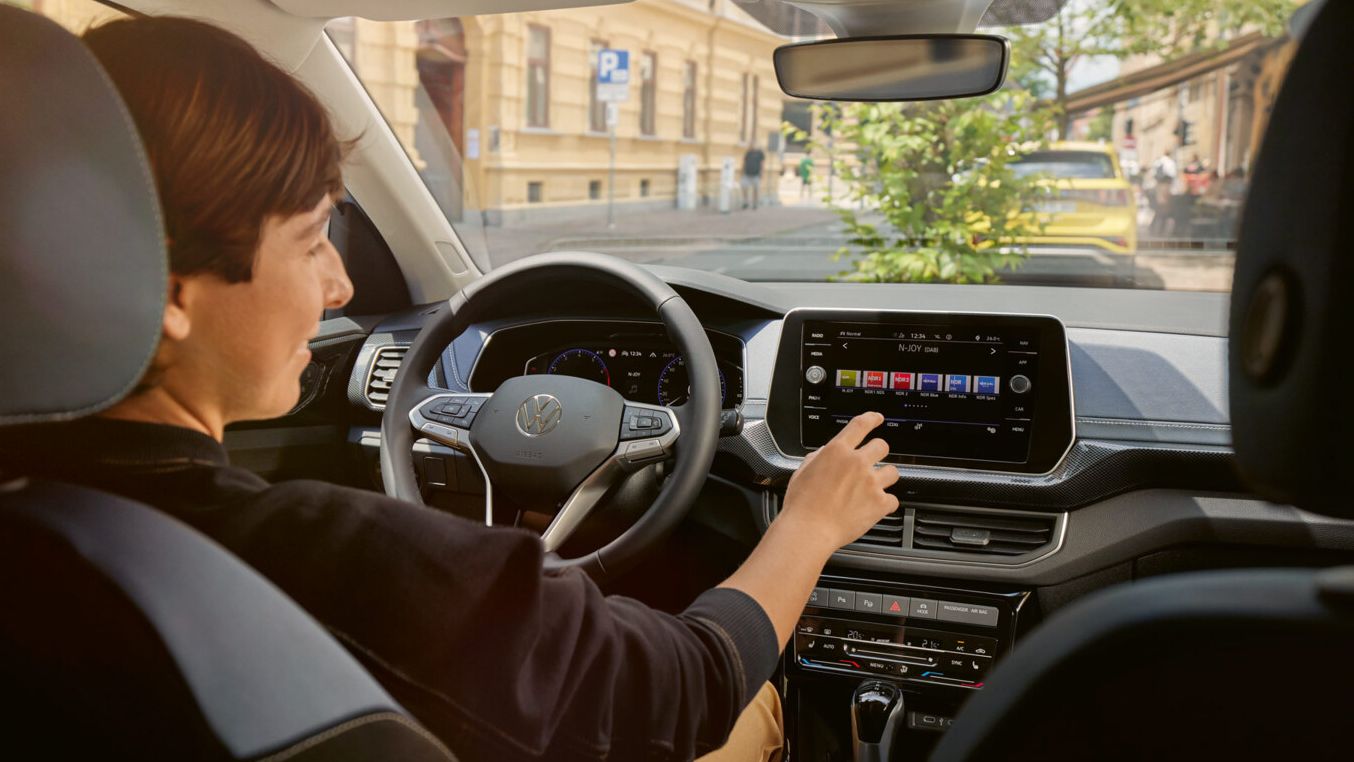 Eine Person nutzt das Infotainment-Display im VW T-Cross.