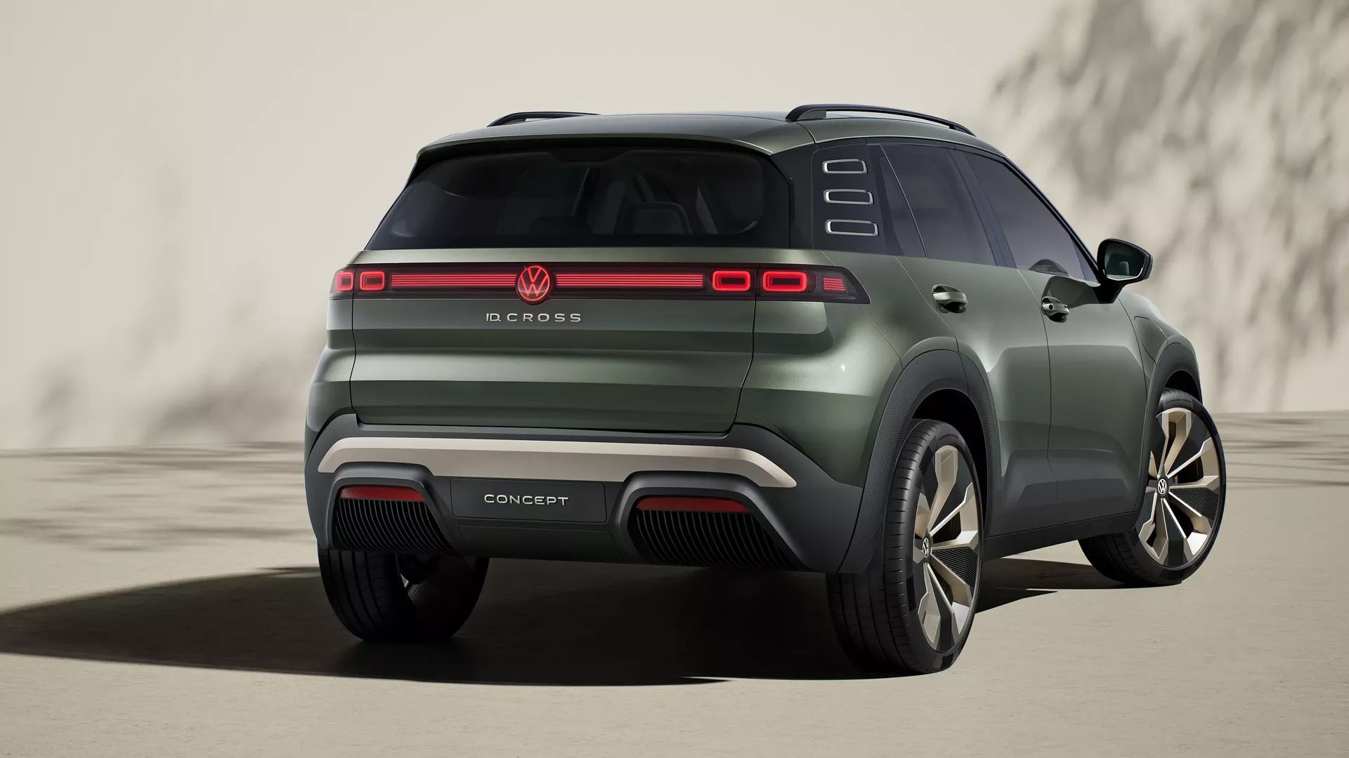 Das Bild zeigt ein grünes Volkswagen SUV-Konzeptfahrzeug, gesehen von schräg hinten. Das Auto hat moderne Rückleuchten und ein futuristisches Design. Im Hintergrund sind Schatten zu sehen.