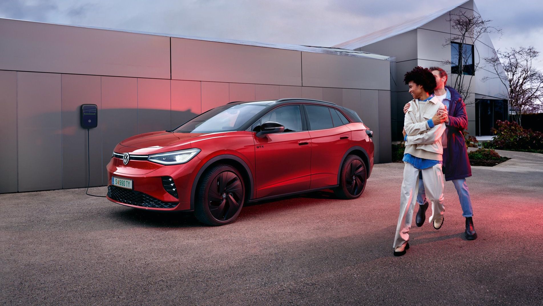 Mann und Frau stehen vor einem ID.4 GTX