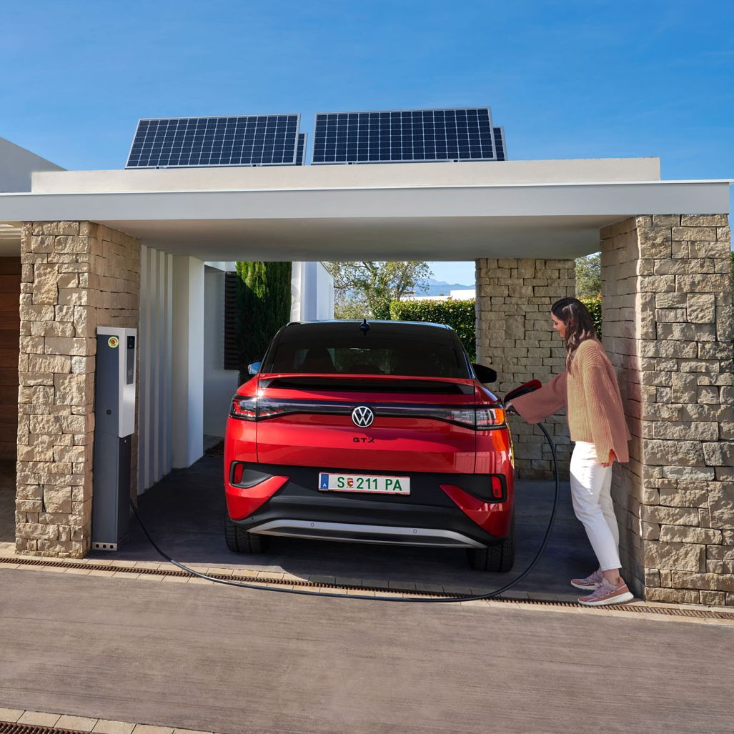 Frau steckt gerade ihren ID.5 GTX im Carport an.