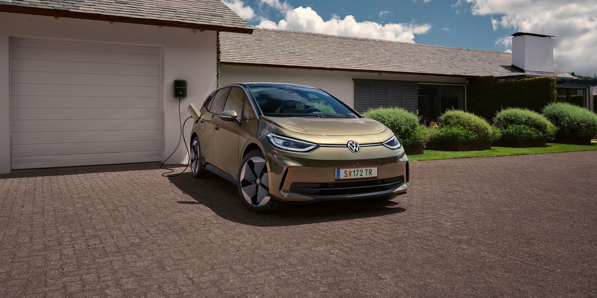 ID.3 steht geparkt vor einem Haus und befindet sich über eine Wallbox angesteckt in einem Ladeprozess. 