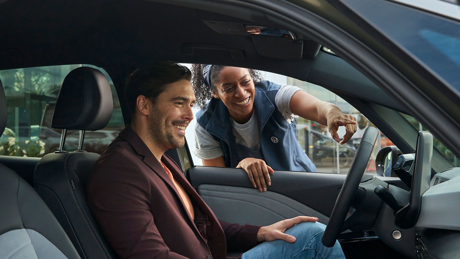 Eine Volkswagen Technikerin erklärt einem Kunden das Display in einem ID.