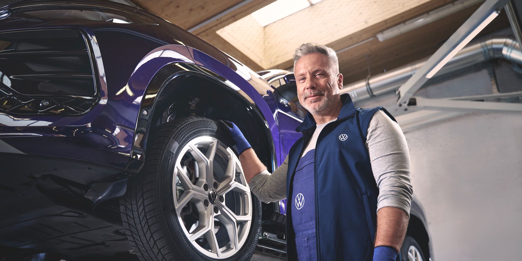 Ein Volkswagen Mechaniker wechselt die Räder bei einem Volkswagen Tayron.