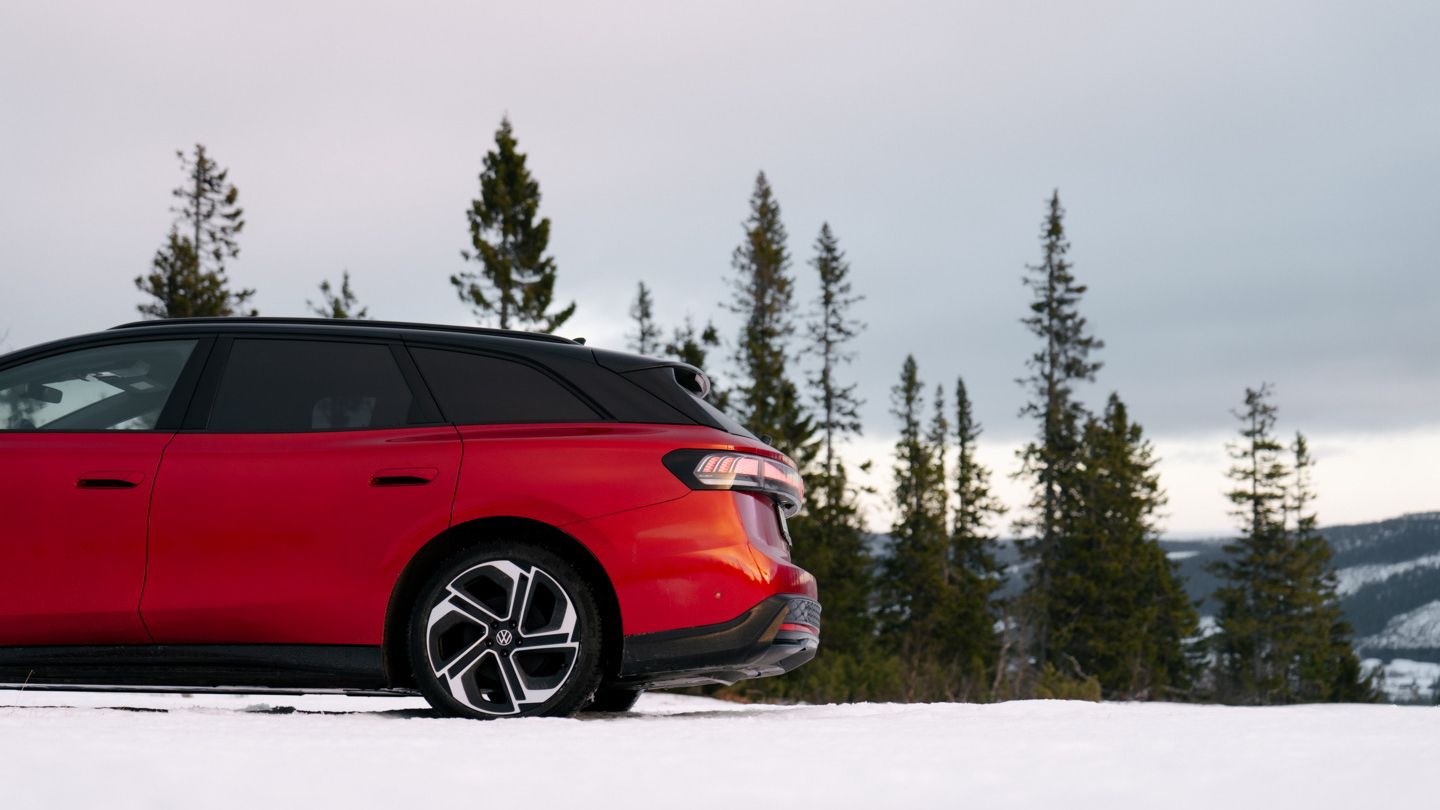 Roter ID.7 GTX steht im Schnee vor dem Wald. 