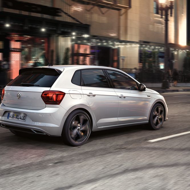 Paar spaziert neben Polo R-Line Vorgängermodell