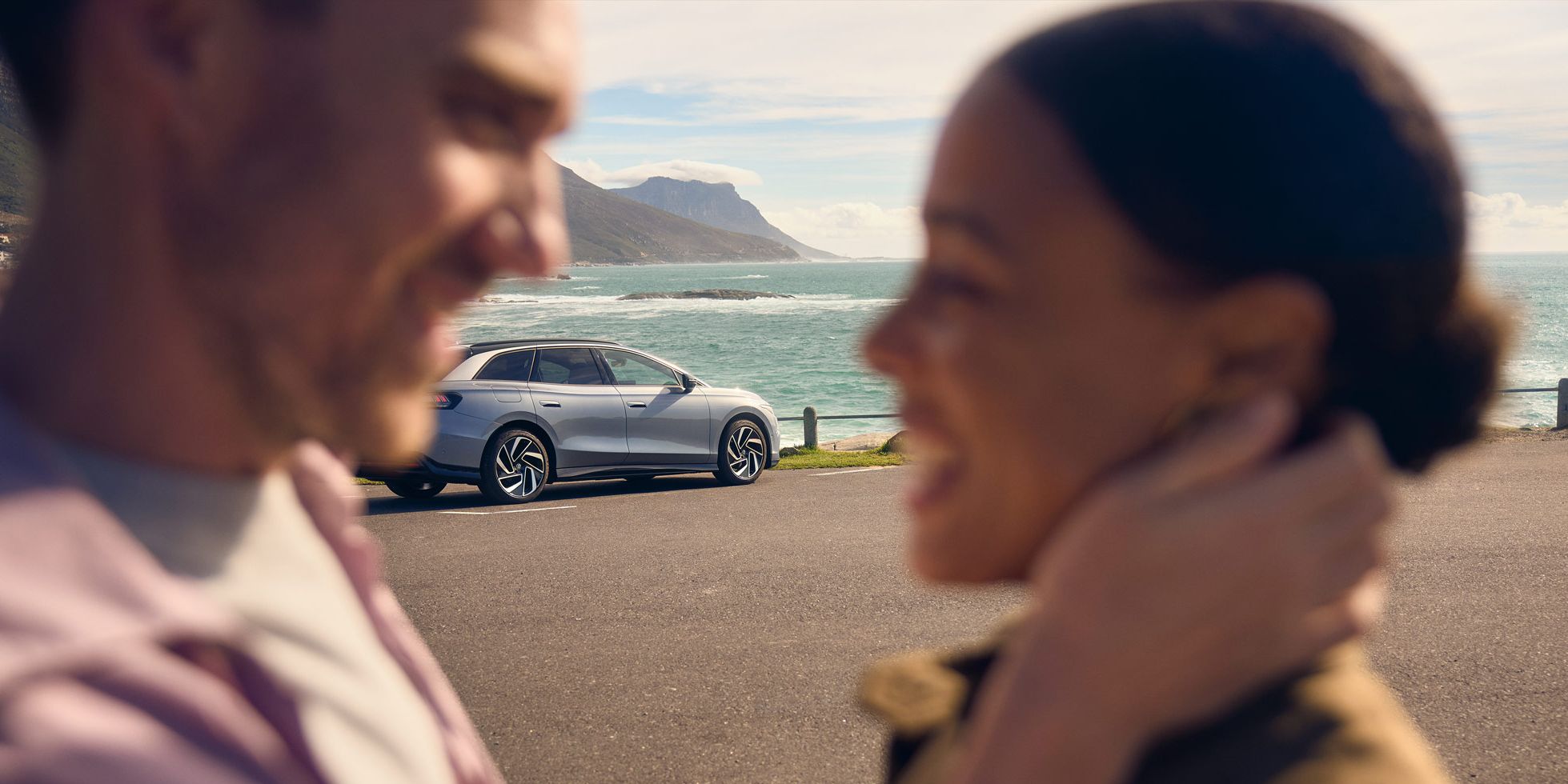 Zwei Personen umarmen sich vor einem ID.7 Tourer.
