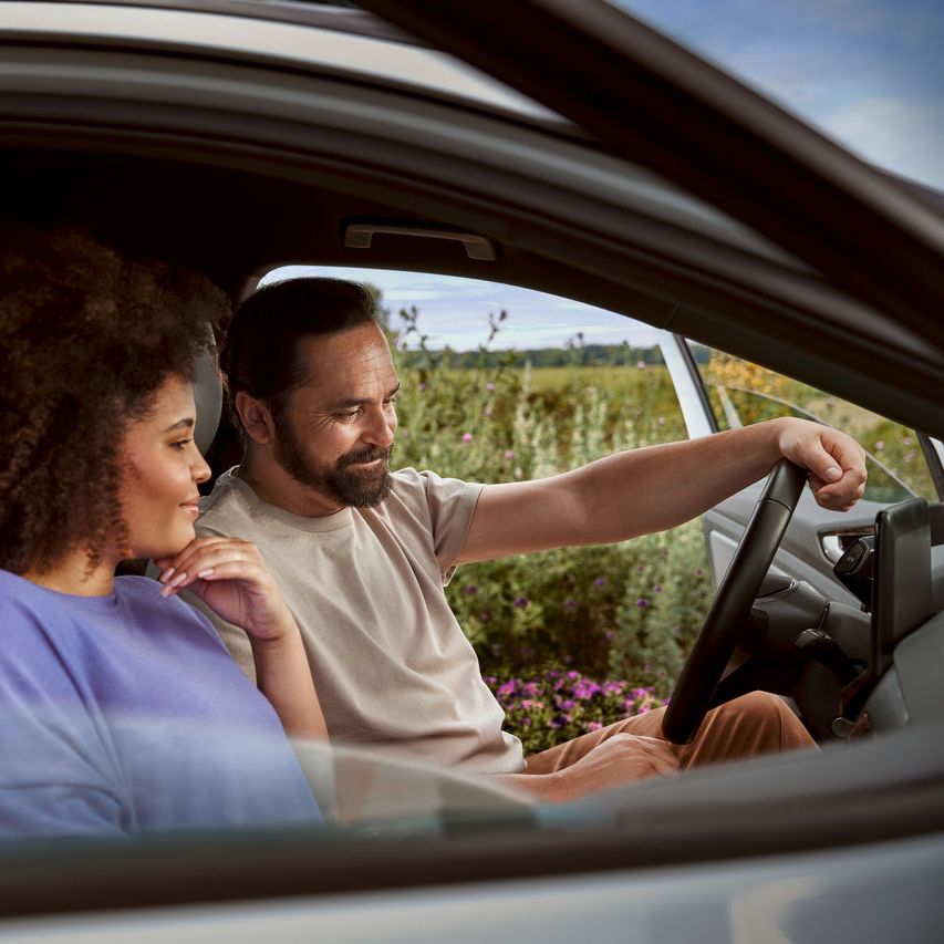 Paar in ihrem Volkswagen blicken aufs Display