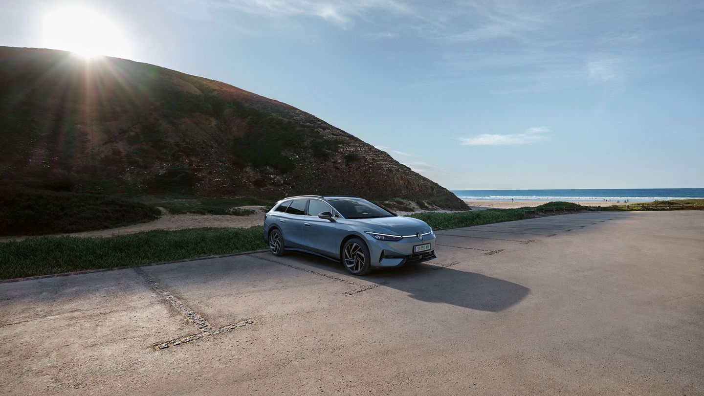 Front- und Seitenansicht eines grau-blauen VW ID.7 Tourer geparkt an der Küste