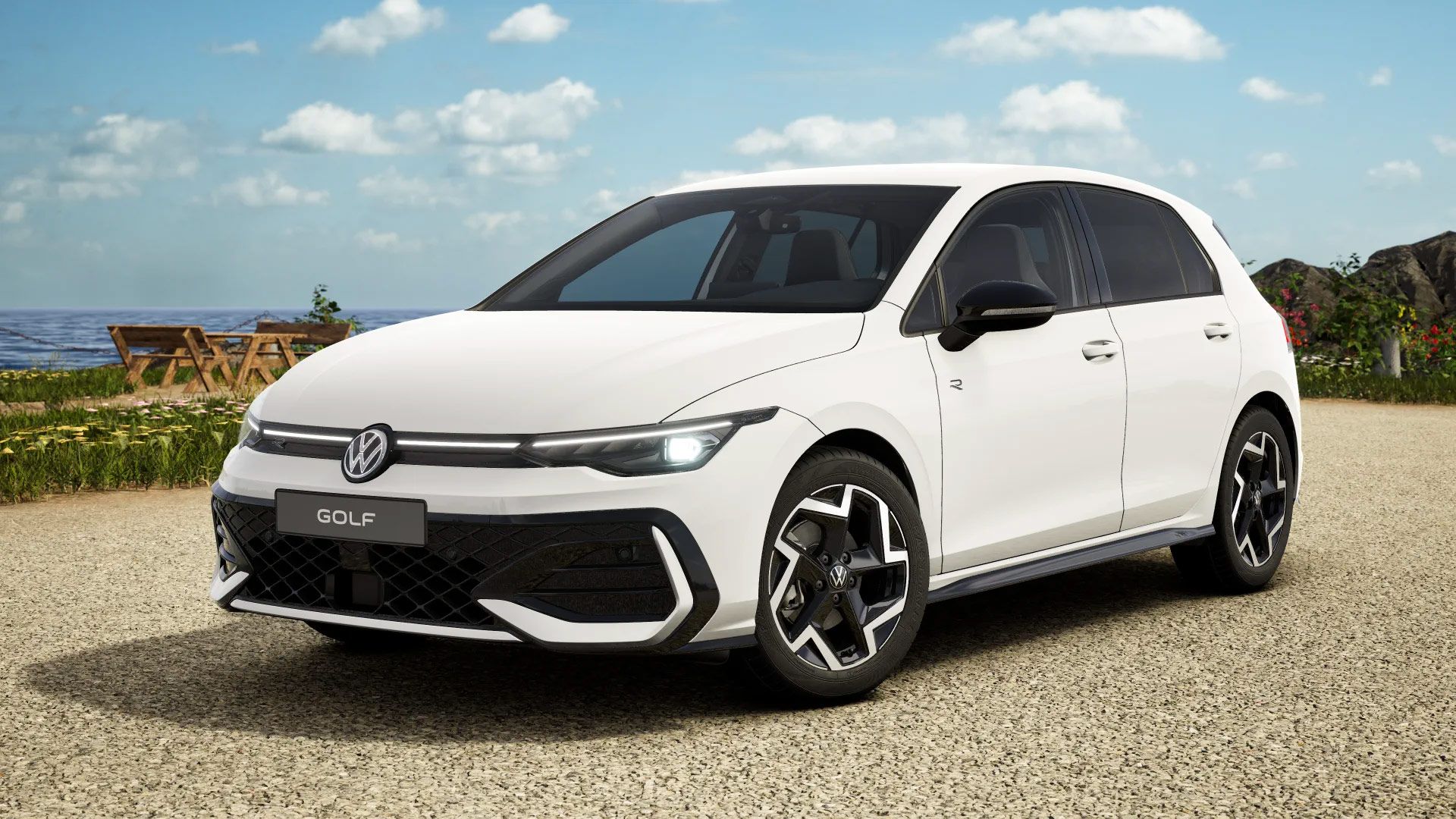 Ein weißer Volkswagen Golf steht auf einem Parkplatz mit Blick aufs Meer. Im Hintergrund sind Tisch und Stühle sowie Wiesen zu sehen. Der Himmel ist teilweise bewölkt.