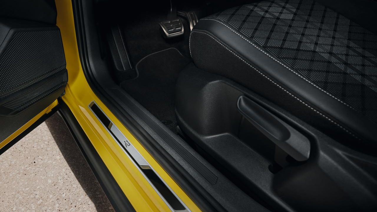 Detail der Einstiegsleiste mit R-Line-Logo auf der Fahrerseite eines VW T-Cross.