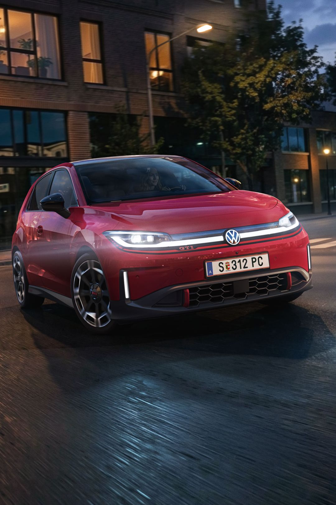Ein roter VW ID. Polo GTI biegt bei abendlicher Stimmung in eine Straße ein.