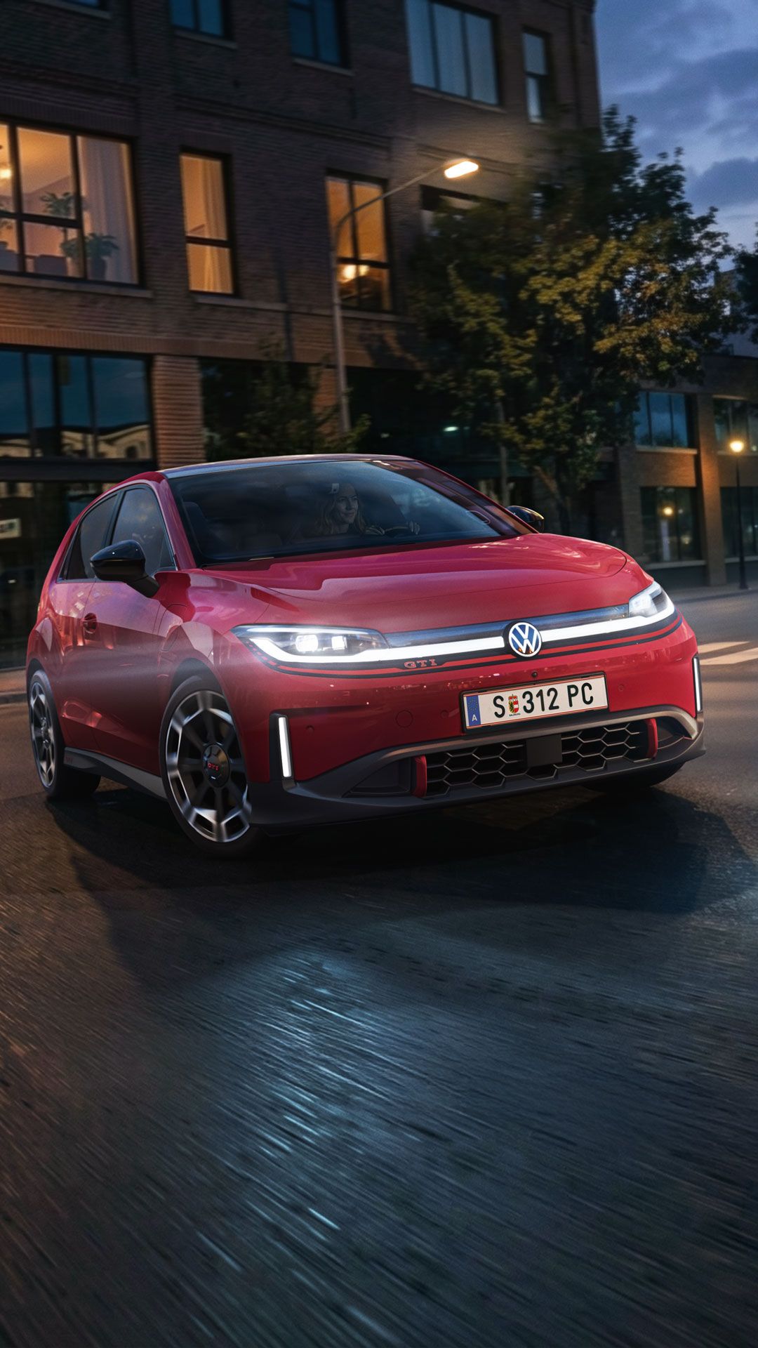 Ein roter VW ID. Polo GTI biegt bei abendlicher Stimmung in eine Straße ein.