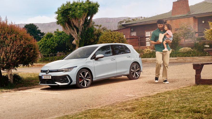 Der VW Golf GTE steht auf einem Parkplatz vor einem Haus.