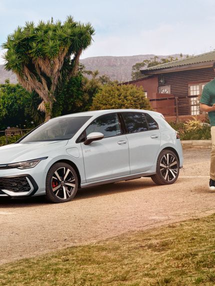 Der VW Golf GTE steht auf einem Parkplatz vor einem Haus.