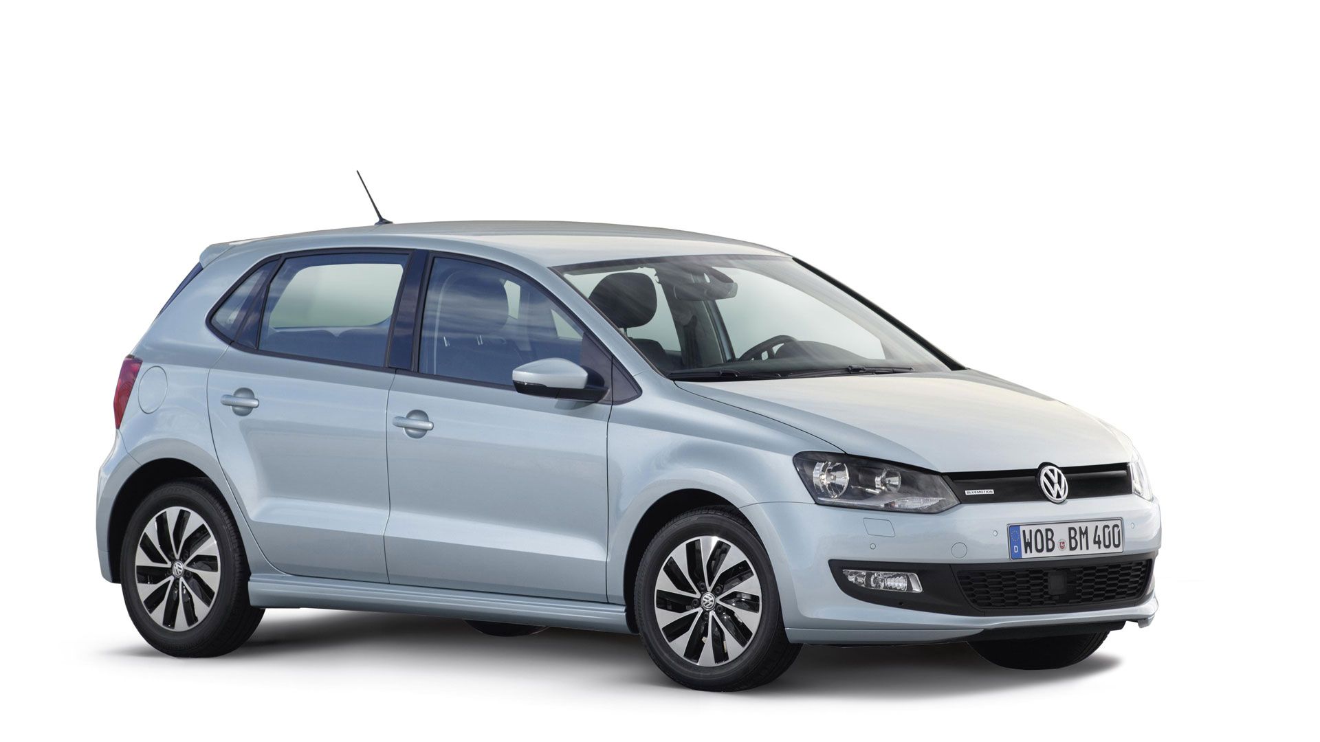 Ein silberner VW Polo 5 mit fünf Türen steht auf einem weißen Hintergrund. Das Auto hat schwarze Akzente an den Fenstern und Scheinwerfern.