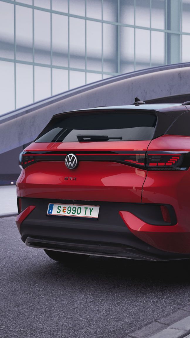 Ein roter ID.4 GTX steht am Straßenrand neben einer Ladesäule