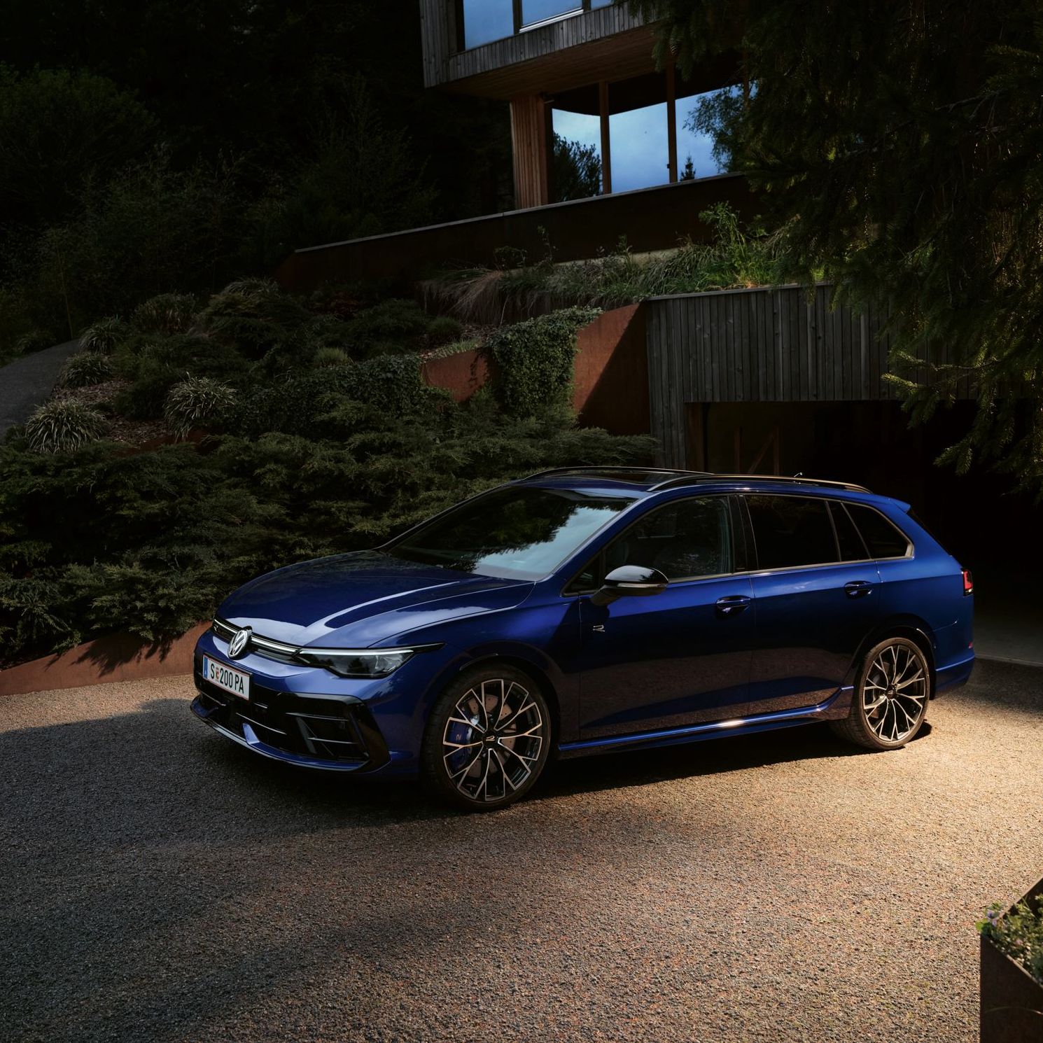 Golf R Variant steht geparkt vor der Garage vor einem Haus.