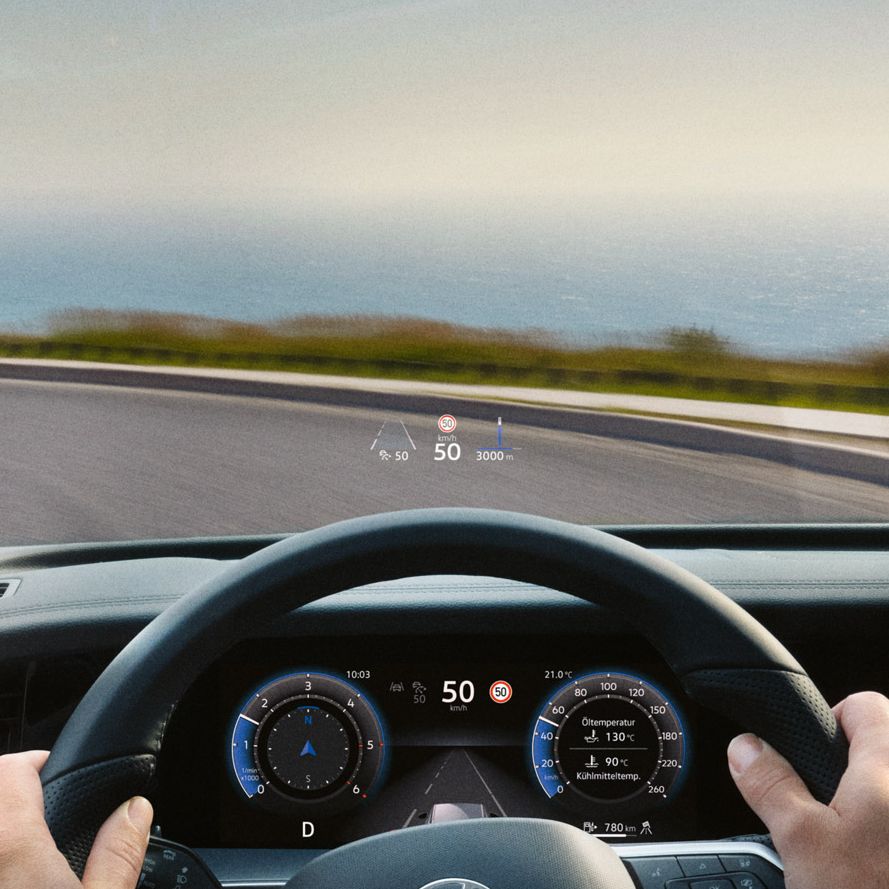 Blick auf das Head-up-Display, Lenkrad und Navigationssystem des VW Tayron während der Fahrt.