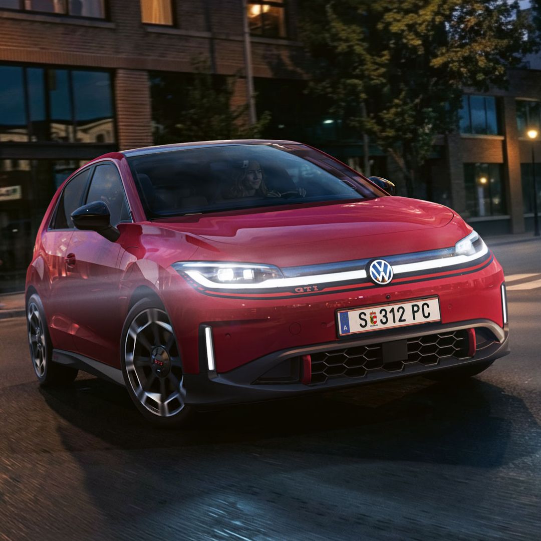 Ein roter VW ID. Polo GTI biegt bei abendlicher Stimmung in eine Straße ein.