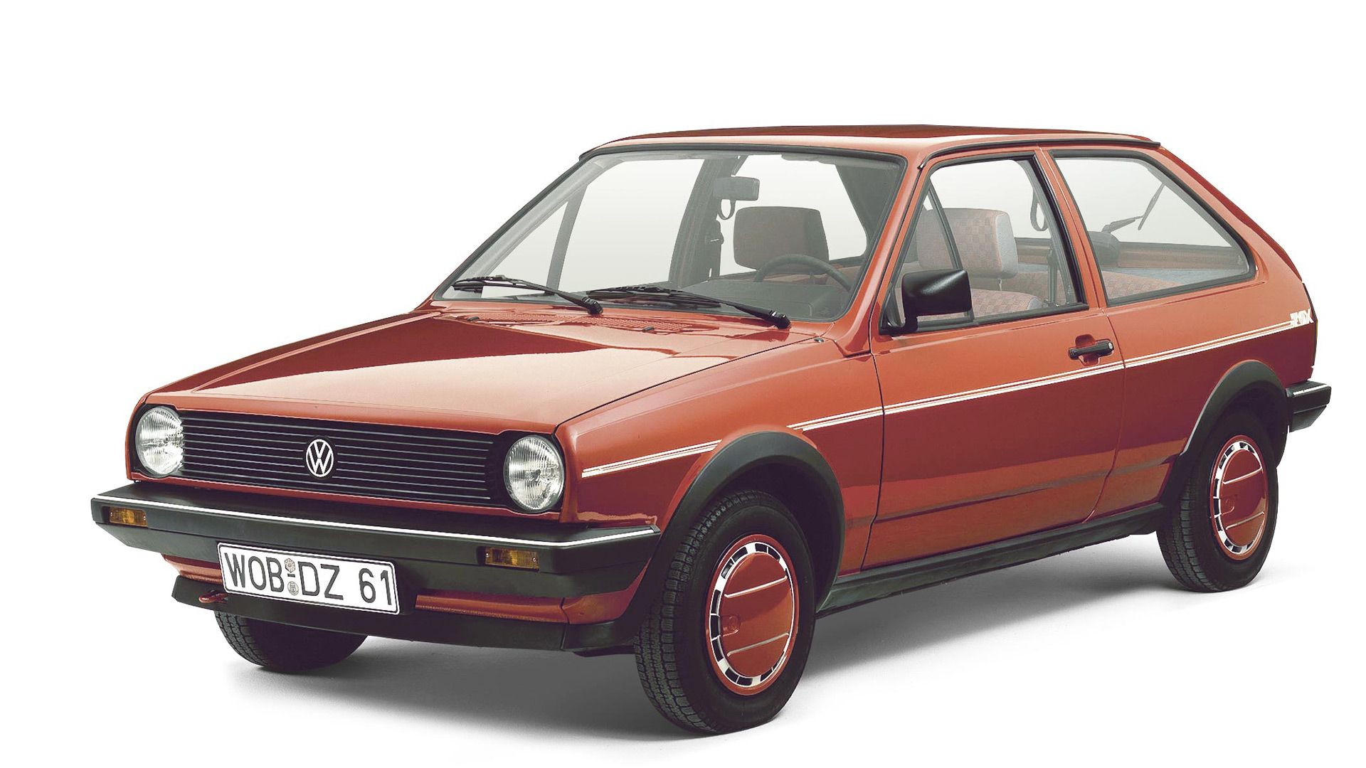Ein roter VW Polo Fox der zweiten Generation, Baujahr 1976-1983, auf weißem Hintergrund. Das Auto hat zwei Türen und runde Scheinwerfer.