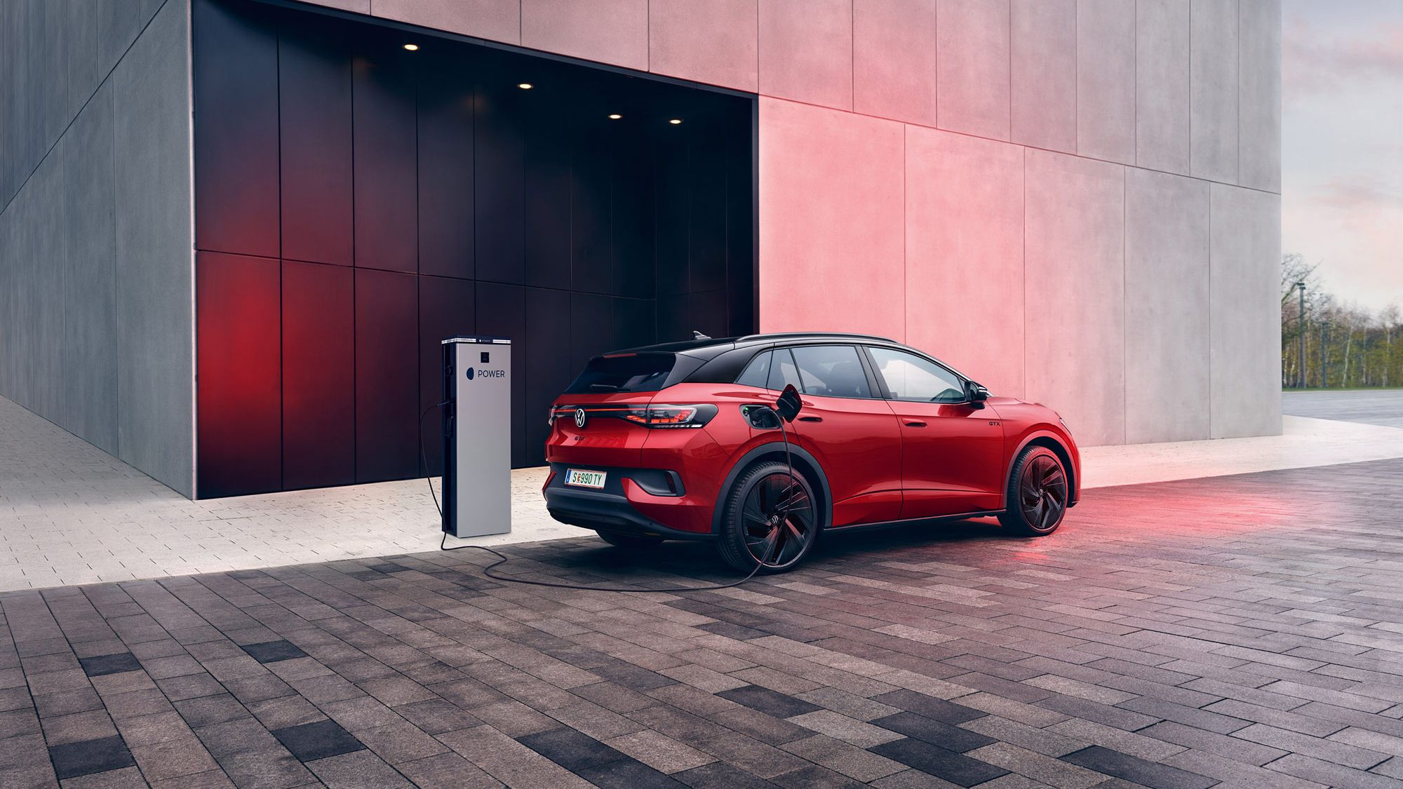 Heckansicht eines VW ID.4 GTX der gerade an MOON Ladestation geladen wird