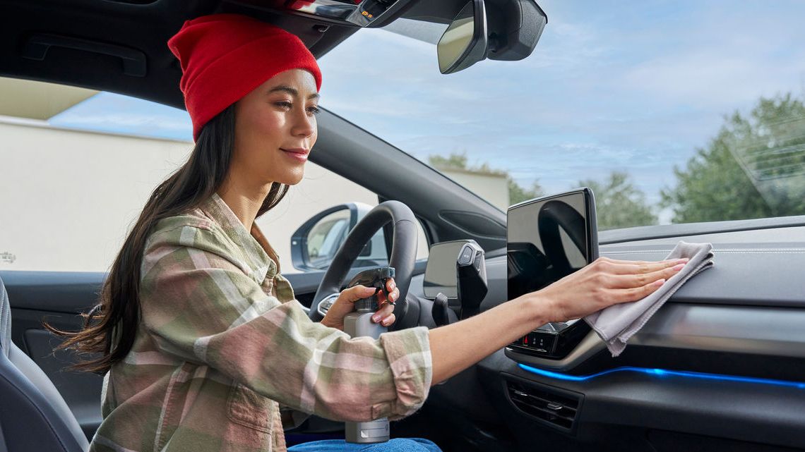 Eine Frau putzt das Cockpit in ihrem Volkswagen