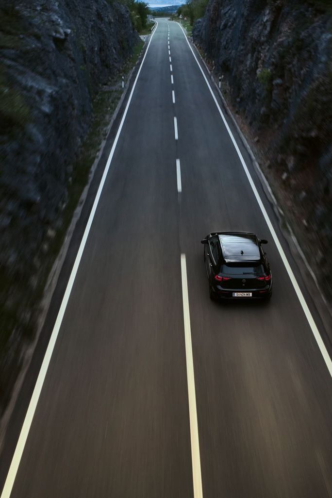 Golf R fährt auf einer Landstraße zwischen zwei Klippen-