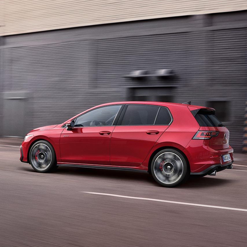 Seitenansicht eines roten Golf GTI der in der Stadt fährt