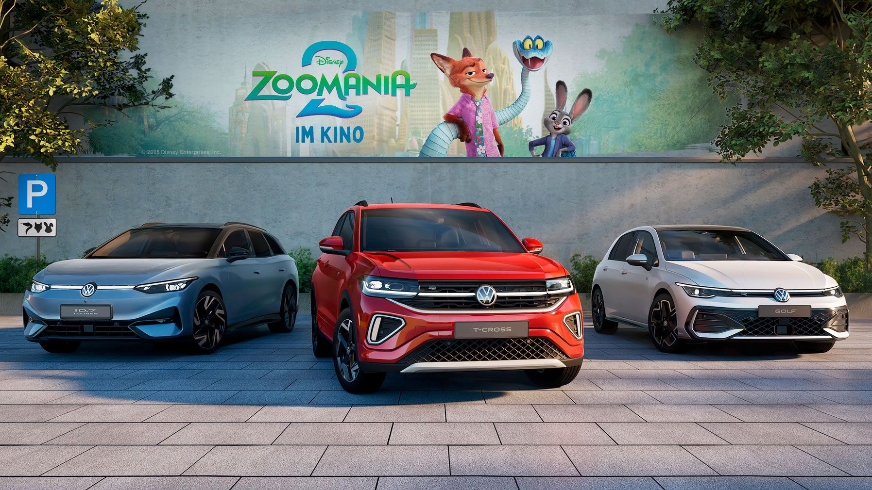 Drei Volkswagen-Fahrzeuge sind nebeneinander auf einem gepflasterten Parkplatz abgestellt. Im Hintergrund ist ein großes Plakat für den Film "Zoomania 2" zu sehen.