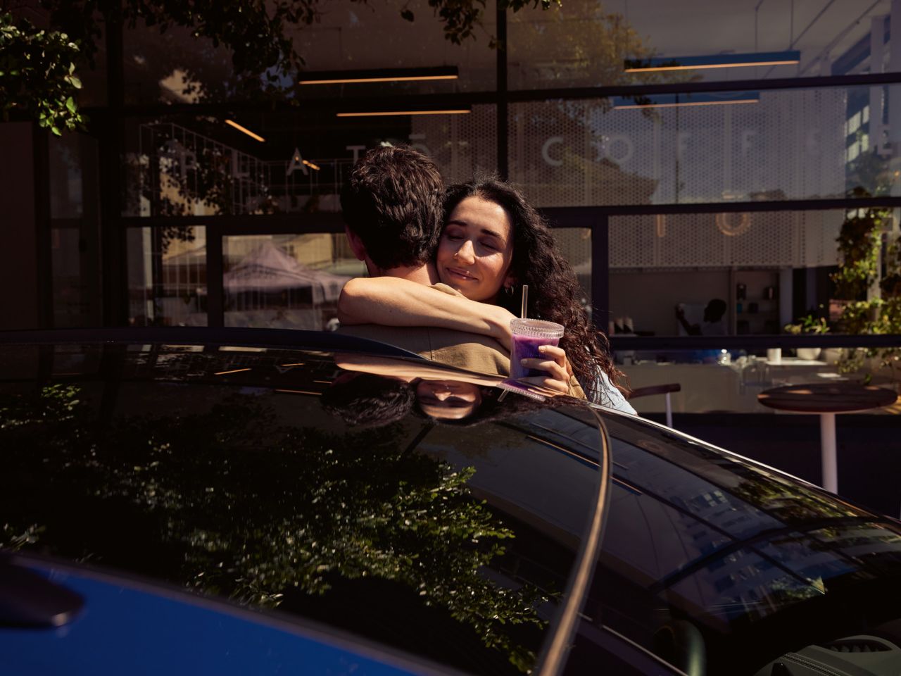 Zwei Personen umarmen sich hinter dem ID.4. 