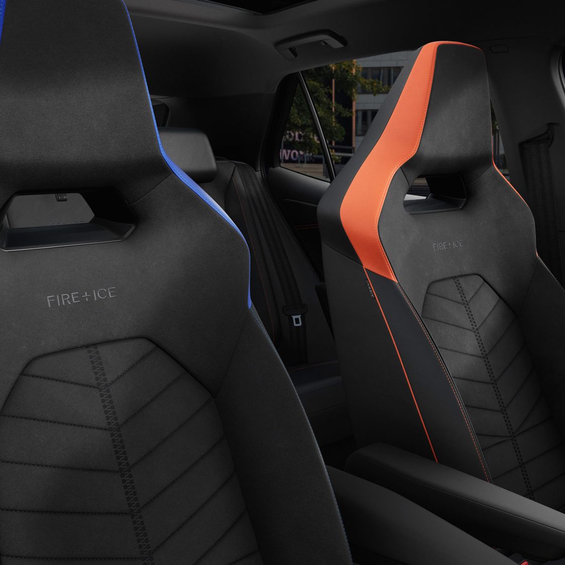 Zwei Rennsportsitze im ID.3 GTX FIRE+ICE, einer ist blau und der andere ist orange. Beide Sitze haben stilvolle Nähte und sind für Komfort und Unterstützung entworfen. Im Hintergrund sind Bäume und Gebäudestrukturen sichtbar.