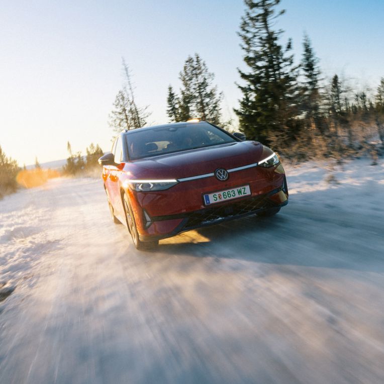Ein roter ID.7 Tourer GTX fährt eine Landstraße entlang. 